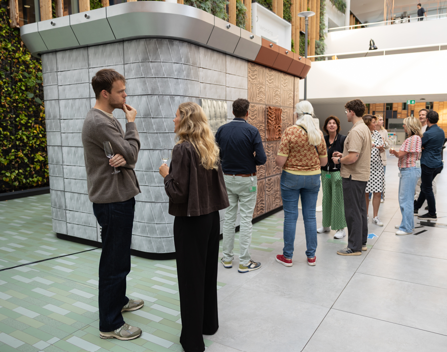 Bezoekers bekijken een grote installatie bekleed met verschillende houten panelen.